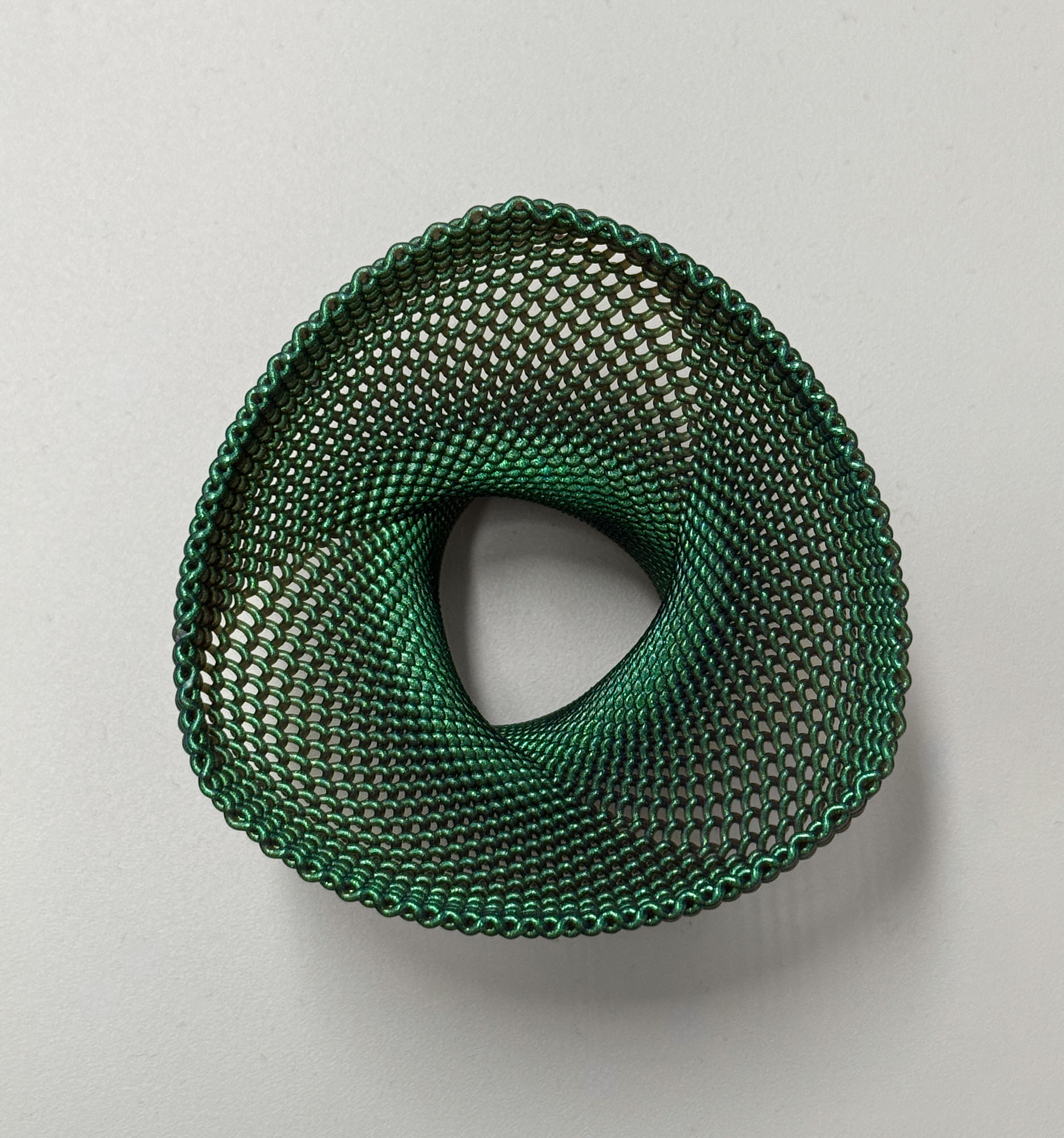 A green spiral-printed shade with an open, woven-looking wall
